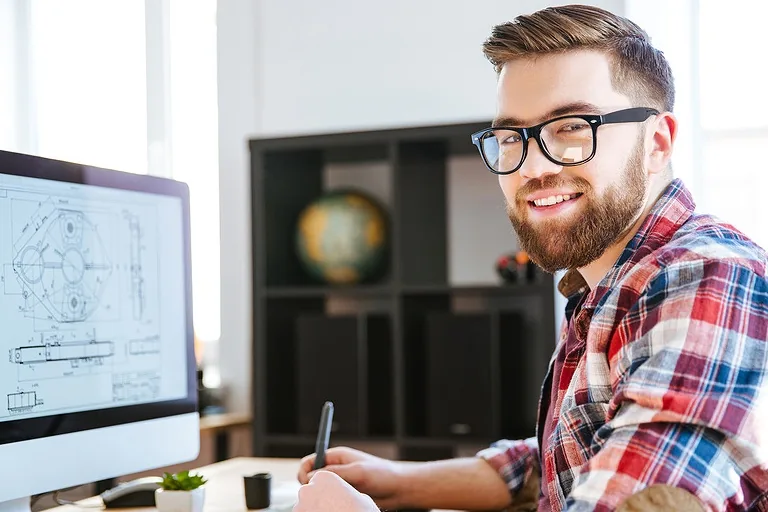 Ontwerper achter een computer met bouwtekening